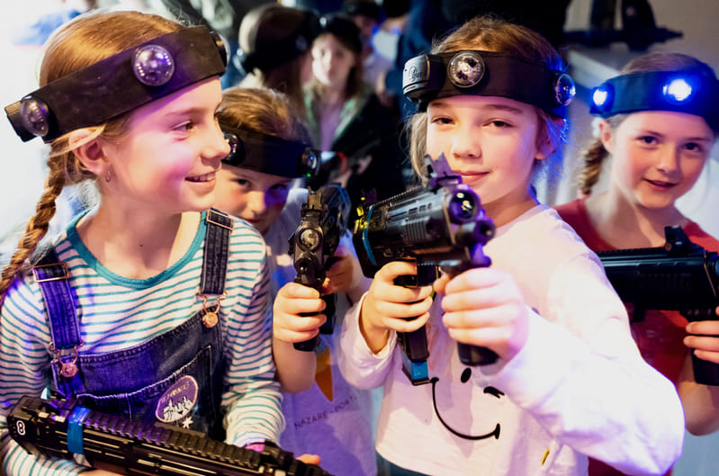 Group of young girls posing with their laser tag guns