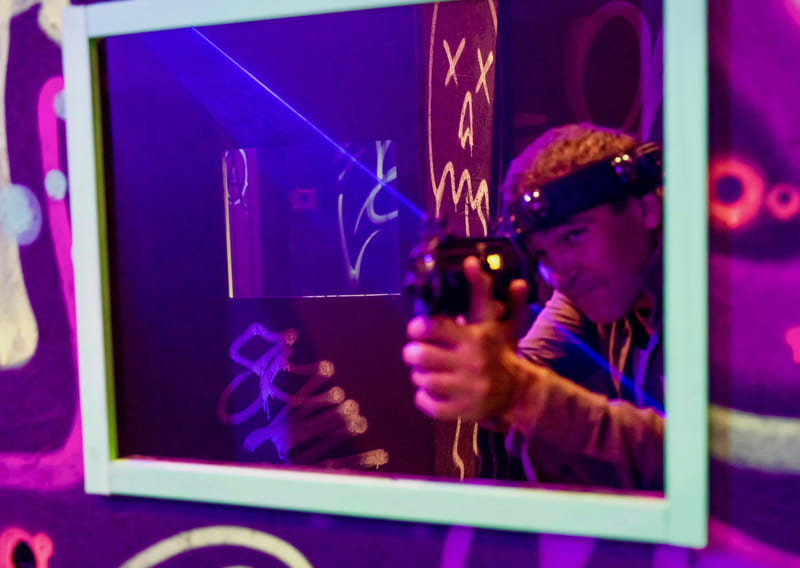Man in a mirror aiming his laser tag gun