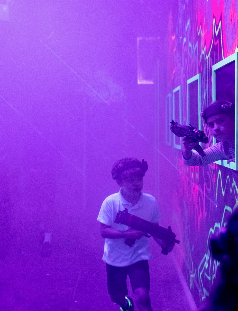 Young boy running through the smoke in the laser tag arena